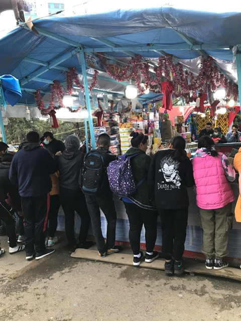 Das Bild zeigt einen Spielstand auf dem Weihnachtsmarkt in La Paz. Zu sehen ist der blaue Stand und davor eine Reihe von Personen, die am Spiel teilnehmen.