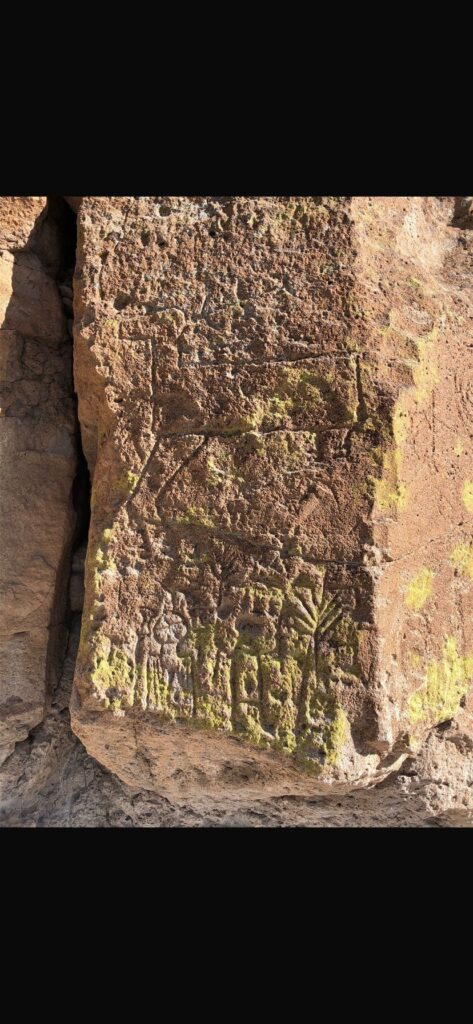 Das Bild zeigt eines der Felsbilder von Tsankawi, einer Ruinenstätte in New Mexico. Felsbilder in Tsankawi zeigen neben der Tierwelt vermutlich religiöse Darstellungen. Hier zu sehen ist ein Hirsch über möglicherweise rituellen Tänzern.